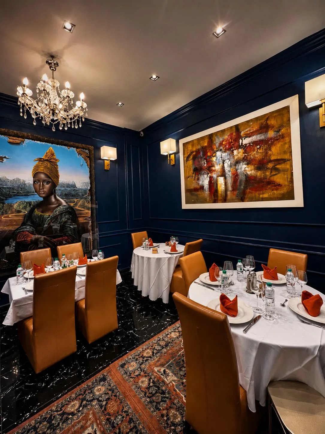 Salle éclairée par un lustre en cristal, tableaux encadrés et tapis à motifs au sol